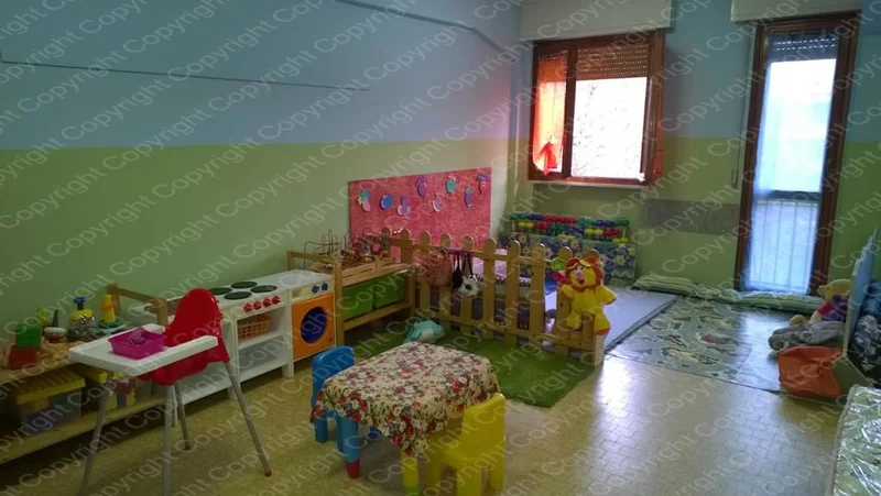 Angolo giochi del Centro Prima Infanzia con cucina giocattolo, tappeto colorato e giochi