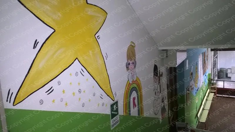 Corridoio del Centro Prima Infanzia decorato con murales di una stella gialla e personaggi colorati