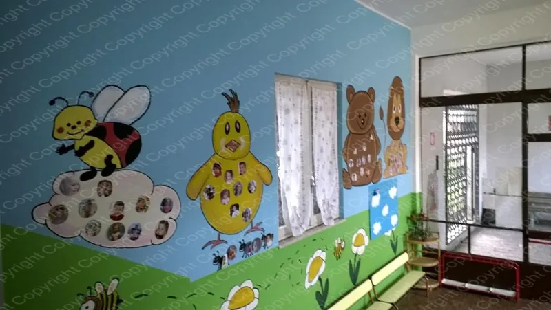 Sala del Centro Prima Infanzia con murales di api, pulcino e orsetto su parete azzurra
